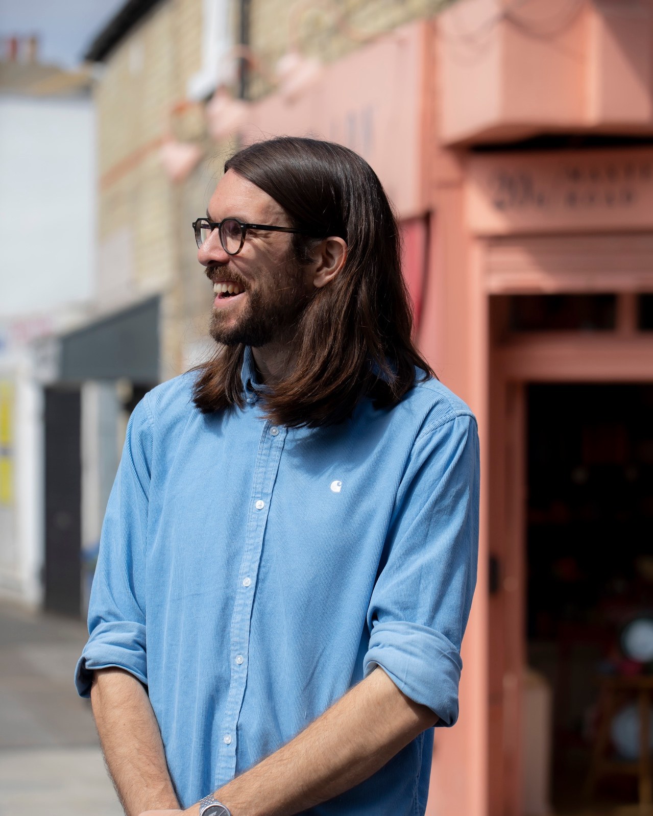 Max Dunne laughing on a London street in a blue shirt