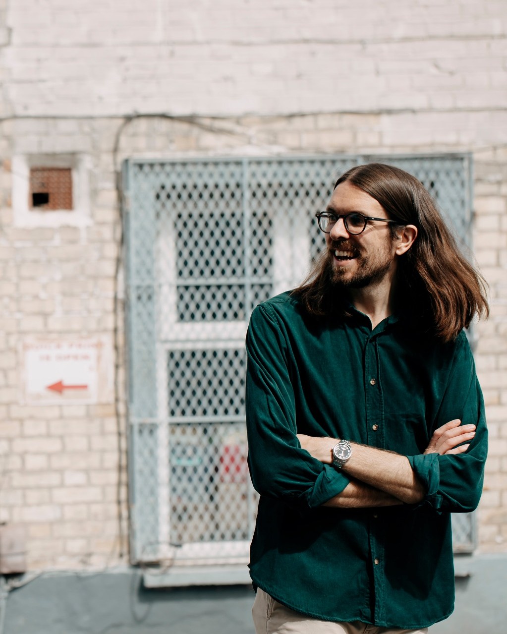 Max Dunne standing outside a printing shop with his arms folded
